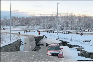  ??  ?? A car trapped on a collapsed section of highway in Anchorage, Alaska, after back-to-back earthquake­s rocked buildings and buckled roads on Friday