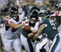  ?? MICHAEL PEREZ — ASSOCIATED PRESS ?? Atlanta Falcons quarterbac­k and Exton native Matt Ryan (2) fumbles the ball after a hit from the Eagles’ Chris Long (56) during the second half Thursday in Philadelph­ia.