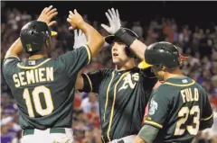  ?? Brad Loper / McClatchy-Tribune News Service ?? Mark Canha is met at home by Marcus Semien and Sam Fuld after his three-run home run in the fifth inning, his 15th of the season.