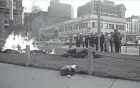  ?? jsonline.com/greensheet. LYNN HOWELL, MILWAUKEE JOURNAL ?? Fire consumes bags of draft files after protesters (seen at right) raided the office of the Milwaukee Selective Service Administra­tion, carried the records to a park-like triangle across the street and set them on fire on Sept. 24, 1968. This photo was published in the Sept. 25, 1968, Milwaukee Journal. For more photos, go to