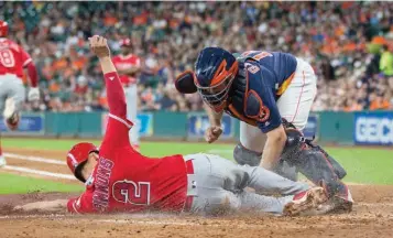  ?? Associated Press ?? Los Angeles Angels' Andrelton Simmons (2) is tagged out by Houston Astros catcher Evan Gattis while trying to score during the fourth inning of a baseball game Sunday in Houston.