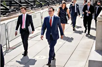  ?? (AP Photo/Andrew Harnik) ?? Treasury Secretary Steven Mnuchin, center, and President Donald Trump’s Chief of Staff Mark Meadows, second from right, leave after a meeting with House Speaker Nancy Pelosi and Senate Minority Leader Sen. Chuck Schumer as they continue to negotiate a coronaviru­s relief package Friday on Capitol Hill in Washington.