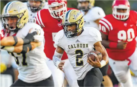  ?? STAFF PHOTO BY DAN HENRY ?? Calhoun High School’s Olico Dennis picks his way through the Dalton High School defense Friday at Harmon Field.