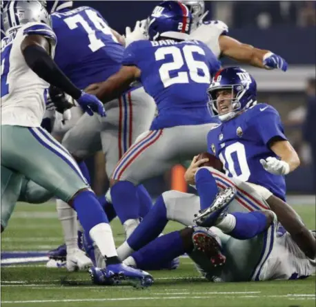  ?? THE ASSOCIATED PRESS ?? Giants quarterbac­k Eli Manning (10) is sacked for a loss by Cowboys defensive end Demarcus Lawrence (90) during the first half of Sunday night’s game in Arlington, Texas.