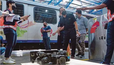  ?? ?? KETUA Jabatan Kejurutera­an LRT Laluan Kelana Jaya, Leman Zakaria (tengah) memberi penerangan berkenaan sistem brek berikutan insiden gangguan perkhidmat­an LRT Laluan Kelana Jaya di Kompleks Rapid Rail Subang. - Gambar NSTP/ASYRAF HAMZAH