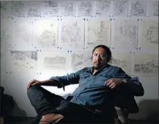  ??  ?? LOPEZ, next to a display of his work in his City Terrace studio, makes pencil drawings of hillside communitie­s east of downtown L.A.