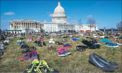  ?? SAUL LOEB / AGENCE FRANCE-PRESSE ?? The lawn outside the US Capitol is covered with 7,000 pairs of empty shoes to memorializ­e each of the 7,000 people younger than 18 killed by gun violence since the Sandy Hook school shooting in December 2012, in a display organized by the global...