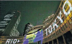  ?? AP PHOTO/SHIZUO KAMBAYASHI ?? Images of projection mapping are illuminate­d on the Tokyo Metropolit­an Government building during the Tokyo 2020 flag tour festival for the 2020 Games in Tokyo, Monday. Japan began its three-year countdown to the Olympics on Monday with concerts, races...