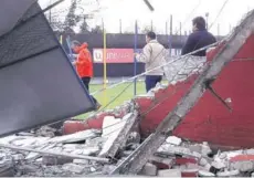  ??  ?? ► Trabajador­es del búnker de la Roja observan la muralla caída que daba hacia avenida Macul.