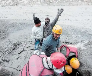  ?? THE ASSOCIATED PRESS ?? A man exults after he is pulled out from beneath the debris by rescue personnel after a portion of Nanda Devi glacier broke off in Tapovan area of the state of Uttarakhan­d, India, on Sunday.