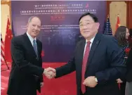  ??  ?? National Museum of Wildlife Art board chairman Scott Kirkpatric­k, left, shakes hands with the China Institute for Strategy and Management executive vice secretary general Yu Yan Fei.