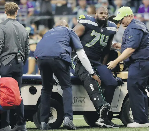  ??  ?? Seahawks offensive tackle George Fant is helped onto a cart after he went down on a play against the Minnesota Vikings during the first half of their pre-season game Friday night in Seattle. Fant suffered a torn ACL and is likely done for the season....