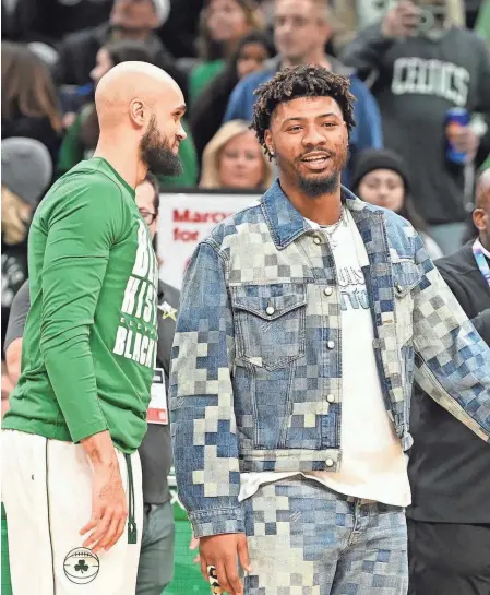  ?? ERIC CANHA/USA TODAY SPORTS ?? Grizzlies guard Marcus Smart has a moment with Celtics guard Derrick White before a game at TD Garden on Sunday in Boston.
