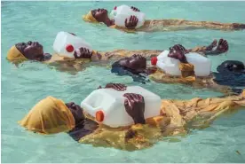  ?? ANNA BOYIAZIS ?? Des femmes tanzanienn­es vêtues de longs maillots apprennent à nager à Zanzibar.