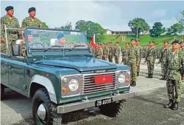  ?? [ FOTO MOHD ROJI KAWI / BH ] ?? Mohd Bustaman memeriksa perbarisan sempena ulangtahun ke-59 Briged Ketiga Infantri di Kem Semenggo, Kuching. Turut kelihatan bekas peninju negara, Mejar Sapok Biki (kanan).