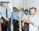  ??  ?? One of the dairy farmers of the Doluwa area lighting the traditiona­l oil lamp as part of the ceremoniou­s opening the Fonterra Milk Chilling Centre in Doluwa