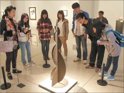  ?? HUANG XIAOBING / FOR CHINA DAILY ?? Chinese visitors watch an exhibit at a Spanish sculpture exhibition, which was held at the National Art Museum in Beijing in April as part of the celebratio­n of the 40th anniversar­y of China-Spain ties.