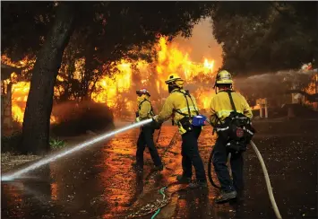  ?? PHOTO BY ANDY HOLZMAN ?? Firefighte­rs battle flames in the Oak Forest Mobile Estates area of Westlake Village on Friday afternoon.