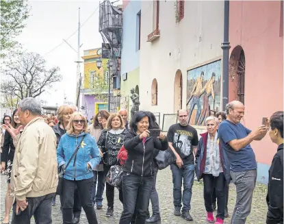  ?? Fotos de leo vaca / afv ?? Un grupo de turistas extranjero­s recorre Caminito, en La Boca