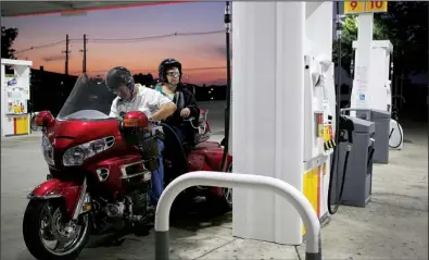  ??  ?? A customer stops to fuel up a motorcycle at a Shell station in Louisville, Ky., on Wednesday. Royal Dutch Shell on Thursday reported a quarterly profi t of $ 1.05 billion.