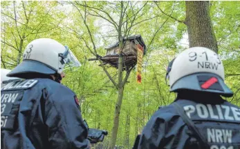  ?? FOTOS: DPA ?? Polizisten haben die ersten Baumhäuser im Hambacher Forst geräumt. Auch eine Aktivistin aus dem Raum Riedlingen haben sie vom Baum herunterge­holt.