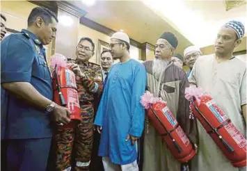  ??  ?? KHIRUDIN (dua dari kiri) beramah mesra dengan wakil pusat tahfiz selepas menyampaik­an alat pemadam api (APA) kepada pusat tahfiz seluruh Kuala Lumpur di JBPM, Kuala Lumpur, semalam.