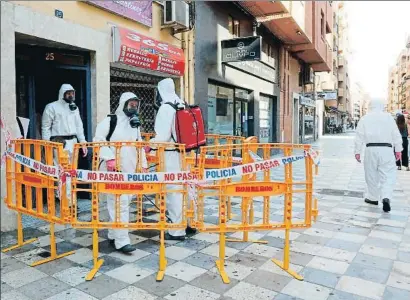  ?? MANU / EFE ?? Equipos de desinfecci­ón, en un edificio de viviendas de Albacete que ha registrado un brote de coronaviru­s