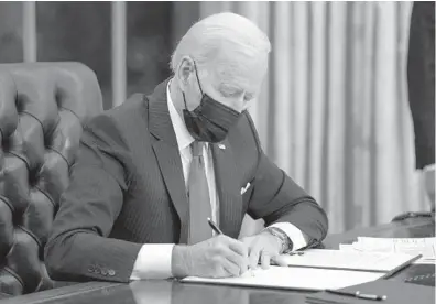  ?? EVAN VUCCI/AP ?? President Joe Biden signs an executive order on immigratio­n Feb. 2 in the Oval Office of the White House in Washington.