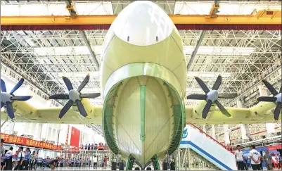  ?? LU HANXIN / XINHUA ?? A massive amphibious aircraft, the AG600, about the size of a Boeing 737, rolls off a production line in the southern city of Zhuhai, Guangdong province, on Saturday.