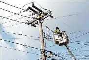  ?? Justin Sullivan/Getty Images ?? Utility workers repair electrical wires in January in Guernevill­e. Utility bills have been high this winter.