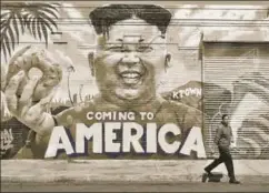  ?? AFP ?? ▪ A pedestrian walks past a mural 'Coming To America' depicting North Korean leader Kim Jongun by graffiti artists in Los Angeles, California, created as part of the Ktown Wallz Project in the city's Koreatown neighbourh­ood.