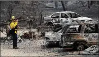  ?? AP/MARCIO JOSE SANCHEZ ?? San Bernardino County
Fire Department firefighte­r James Lippen takes photos of the damage caused by a wildfire Sunday, in Keswick, Calif.