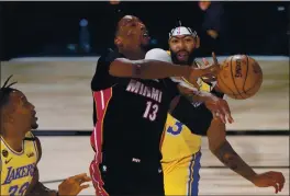  ?? MARK J. TERRILL — THE ASSOCIATED PRESS ?? The Lakers’ Anthony Davis, right, stops the Heat’s Bam Adebayo on a drive to the basket during Game 1 of NBA Finals. Adebayo is doubtful for Game 2 tonight.