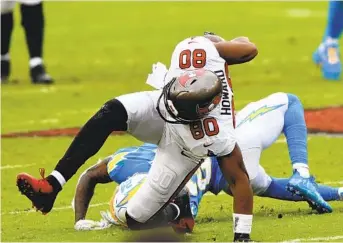  ?? JASON BEHNKEN AP ?? Buccaneers tight end O.J. Howard is taken down by Chargers free safety Nasir Adderley on Sunday.