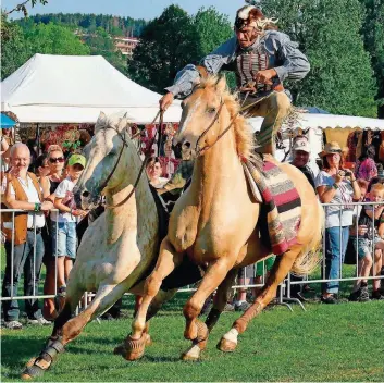  ??  ?? Stehend auf zwei Pferden: Akteur der Plains Indians galoppiert bei der Reitershow rasant durchs Rund.