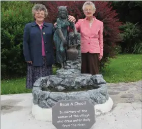  ??  ?? Nancy Murphy (Sister Brendan) on left and her sister Kit at the statue commemorat­ing the women of Chapeltown (Caol), who drew water from the nearby river and well in bygone days. The two ladies also drew water in their youth.