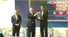  ??  ?? Azmir (middle) receives the Halal CSR Excellence Award from Dr Khalid Abdul Hamid (right), Director of Services Industry Division, Ministry of Economic Affairs, witnessed by HDC vice president of industry developmen­t Hanisofian Alias during the World Halal Conference 2019.