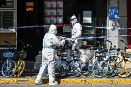  ?? AFP/VNA Photo ?? Workers mark a perimeter around a neighborho­od under a COVID-19 coronaviru­s lockdown in the Jing'an district in Shanghai on May 4.