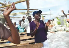  ??  ?? LES CAYES: Members of an evangelic church attend church damaged by Hurricane Matthew, in the commune of Roche-a-Bateaux. — AFP