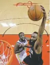  ?? DAVID J. PHILLIP/ASSOCIATED PRESS ?? Rockets guard James Harden scores over Warriors forward Kevon Looney on Thursday.