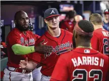  ?? JASON GETZ / JASON.GETZ@ AJC.COM ?? Right-hander Michael Soroka (center) greets teammates after pitching into the sixth inning against the Marlins on June 30 at Truist Park. Before Tuesday, he hadn’t made a home start since July 16.