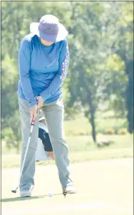  ?? Westside Eagle Observer/MIKE ECKELS ?? Faye Gilbert, a longtime Decatur resident, keeps her eye on the ball as she gets ready to putt the ball towards the pin on one of the holes during the 2020 Decatur Police Department Golf Tournament fundraiser at the Creeks Golf Course in Cave Springs Friday.