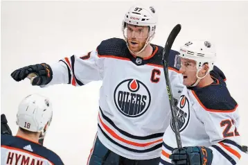  ?? GENE J. PUSKAR THE ASSOCIATED PRESS ?? Edmonton Oilers captain Connor Mcdavid celebrates with Tyson Barrie and Zach Hyman after scoring in the third period against the Penguins in Pittsburgh on Tuesday night. The Oilers won, 5-1.