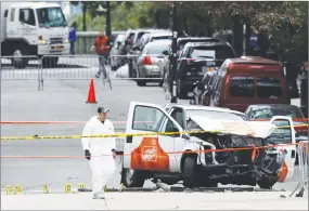  ?? AP PHOTO ?? A law enforcemen­t officer walks by a crime scene after a driver mowed down people on a riverfront bike path near the World Trade Center in New York.