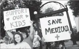  ?? JOSHUA L. JONES/ATHENS BANNER-HERALD VIA AP ?? Madison Boswell, left, who is on the autism spectrum, and her mother, Amy Boswell, protest Wednesday at the University of Georgia Arch in Athens, Ga., during a rally for special needs children who would be affected by the Senate health care bill,