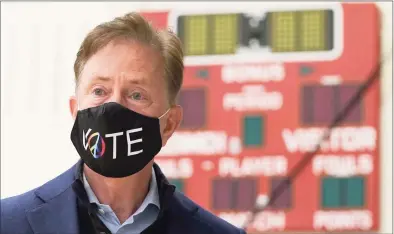  ?? Timothy A. Clary / AFP via Getty Images ?? Gov. Ned Lamont prepares to cast his vote at Greenwich High School on Nov. 3.