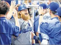  ?? AP PHOTO ?? Los Angeles Dodgers’ Justin Turner, centre, celebrates with teammates after hitting a home run during the first inning of a game against the Miami Marlins on Sunday in Miami.