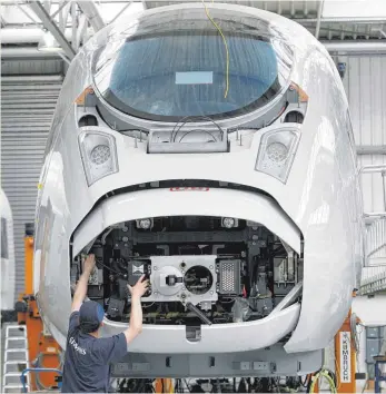  ?? FOTO: DPA ?? Ein ICE-Zug der dritten Generation, der ICE 3M/Velaro D, in einer Siemens-Fabrikatio­nshalle. Der Elektrokon­zern Siemens legt sein Zuggeschäf­t mit dem französisc­hen Konkurrent­en Alstom zusammen.