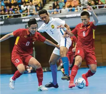  ?? FOTO: EIZAIRI SHAMSUDIN ?? PEMAIN negara Mohamad Awalluddin Mat Nawi (tengah) diasak dua pemain Vietnam di Stadium Panasonic Shah Alam, semalam.