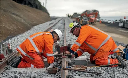  ?? PHOTOS: ALDEN WILLIAMS/STUFF ?? Members of the KiwiRail rebuild team complete a symbolic weld to represent the joining of the line between Picton and Kaikoura.